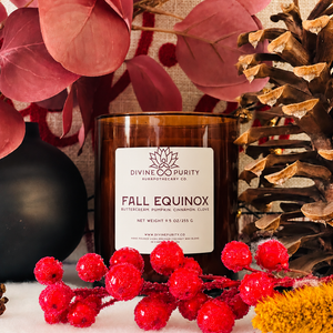 Divine Purity Equinox candle with red berries, burgundy leaves and a pinecone