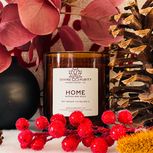 Divine Purity Home candle with red berries, burgundy leaves and a pinecone
