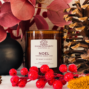 Divine Purity Noel candle with red berries, burgundy leaves and a pinecone