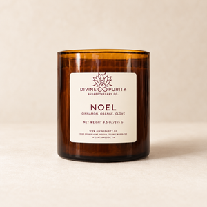 Divine Purity Noel candle on a warm cream background with a soft shadow